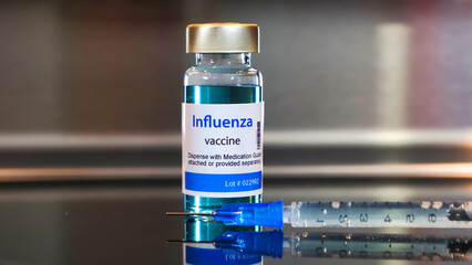 Bottle of influenza vaccine with stainless steel background.