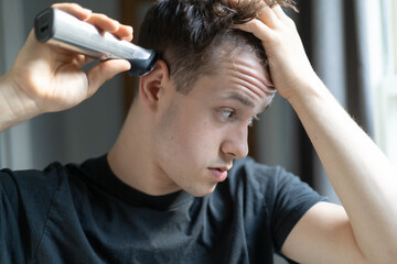 Young man giving himself a haircut