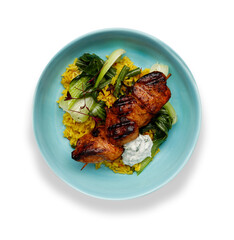 A delicious bowl of  tandoori chicken, vegetables and rice, in a light blue bowl isolated on white