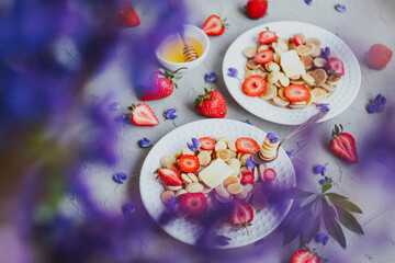 Pancake cereal, trendy food. Mini cereal pancakes with butter, honey, and strawberries.