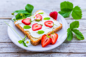 A delicious sandwich with mascarpone and fresh strawberries. Healthy breakfast.