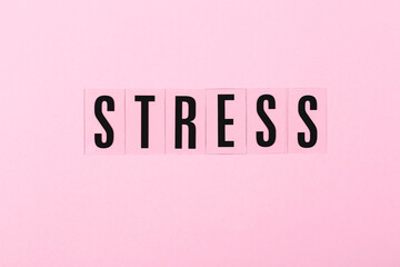 Letters STRESS onthe pink background. Negative emotions concept.