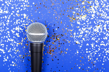 ASMR, karaoke, singing, voice recording concept.  A microphone on blue background decorated with...