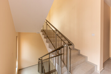 Modern stair case between floors. Stairs with metallic rail in modern building