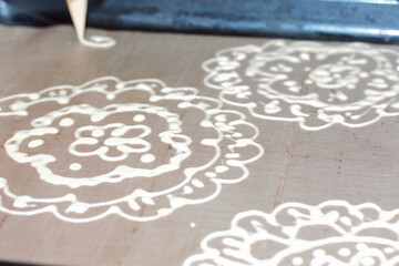 Woman makes a pattern of dough on a baking sheet. For the preparation of biscuit roll with spinach and mint. Stuffed with strawberries. Ingredients for cooking.