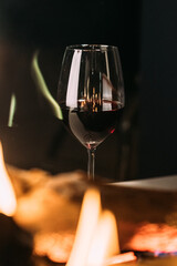 A glass of red wine with a fireplace. High quality photo. 