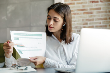 Attractive young brunette woman working on laptop computer