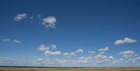 A landscape picture on the Canadian Prairies as farmers seed their crops in Rockyview County under a dramatic cloudy sky.