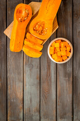 Pumpkin - slices on cutting board - on wooden background top-down space for text
