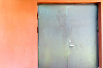 Nice brown gray painted metal door in a plastered wall