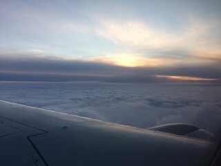 Spectacular view of the horizon in gray-purple clouds from the plane window