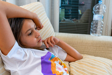 Portrait of beautiful little girl posing on white sofa in home living room