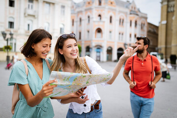 Happy traveling tourists sightseeing with map in hand