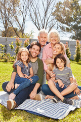 Three generations of a family are sitting in the garden