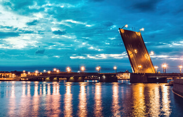 Fototapeta na wymiar An illuminated drawbridge in Saint Petersburg at white night and reflections on water. Troitskiy Bridge. Concept of travelling to russia. Famous place. 