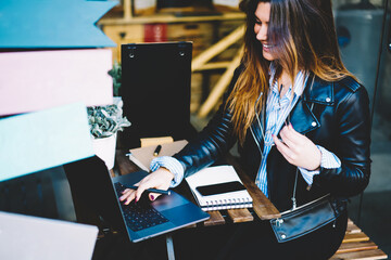 Cropped image of cheerful young woman copywriter working at modern laptop computer device using...