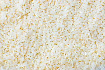 White rice is scattered on the table. Rice texture close up. The concept of good nutrition and vegetarianism.
