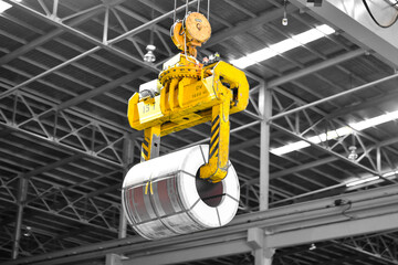 Overhead crane lift up steel coil with tong in wearhouse. Steel coils handling equipment. Steel...