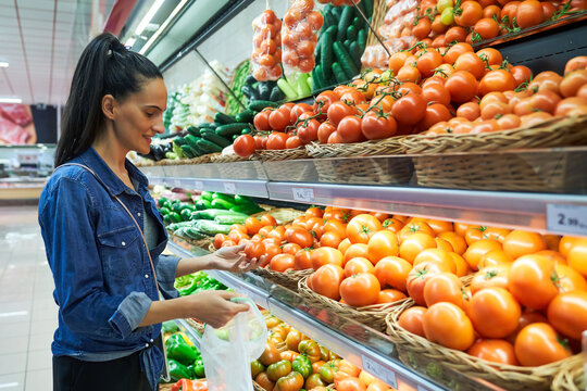 Girl buying fruit and vegetables using recyclable bags