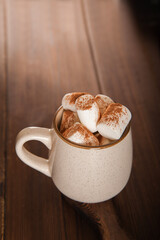 Concept with marshmallows in a circle on a dark background. Autumn, coffee, tea, mug, marshmallows, cozy. Fall concept closeup and copy space on dark background.