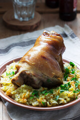 Baked pork knuckle served with stewed cabbage and beer. Rustic style.