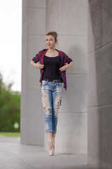 Girl ballerina in jeans, a plaid shirt and pointe shoes dancing in the city on the street © Tatiana