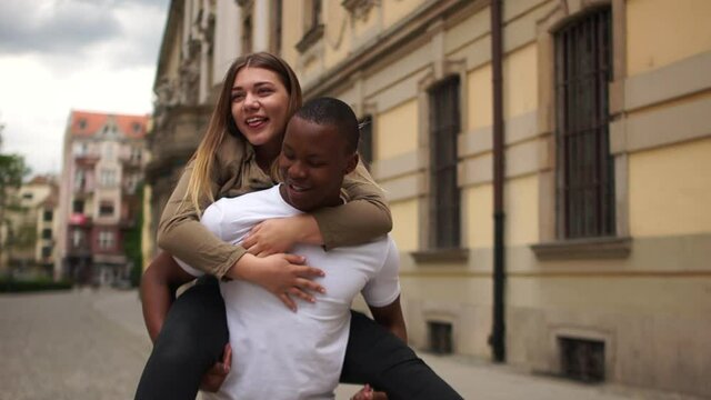 A black man and a caucasian woman have fun on a city street. Young interracial couple in love, Valentines Day, black and white couple