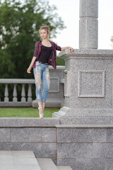 Girl ballerina in jeans, a plaid shirt and pointe shoes dancing in the city on the street © Tatiana