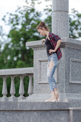 Girl ballerina in jeans, a plaid shirt and pointe shoes dancing in the city on the street © Tatiana