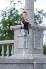 Girl ballerina in jeans, a plaid shirt and pointe shoes dancing in the city on the street © Tatiana