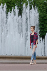 Girl ballerina in jeans, a plaid shirt and pointe shoes dancing in the city on the street © Tatiana