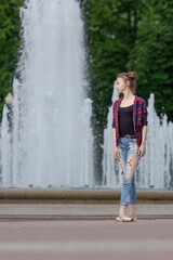 Girl ballerina in jeans, a plaid shirt and pointe shoes dancing in the city on the street © Tatiana