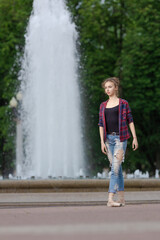 Girl ballerina in jeans, a plaid shirt and pointe shoes dancing in the city on the street © Tatiana