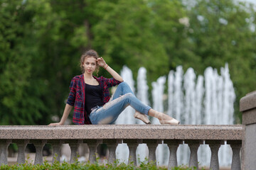 Girl ballerina in jeans, a plaid shirt and pointe shoes dancing in the city on the street © Tatiana