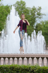 Girl ballerina in jeans, a plaid shirt and pointe shoes dancing in the city on the street © Tatiana