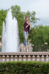 Girl ballerina in jeans, a plaid shirt and pointe shoes dancing in the city on the street © Tatiana