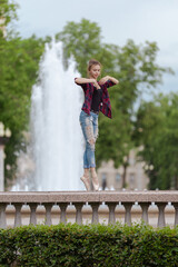 Girl ballerina in jeans, a plaid shirt and pointe shoes dancing in the city on the street © Tatiana