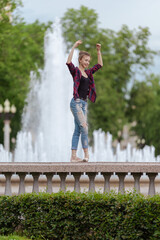 Girl ballerina in jeans, a plaid shirt and pointe shoes dancing in the city on the street © Tatiana