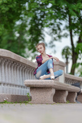 Girl ballerina in jeans, a plaid shirt and pointe shoes dancing in the city on the street © Tatiana