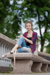 Girl ballerina in jeans, a plaid shirt and pointe shoes dancing in the city on the street © Tatiana