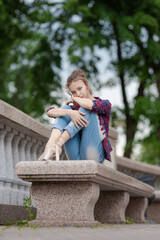 Girl ballerina in jeans, a plaid shirt and pointe shoes dancing in the city on the street © Tatiana