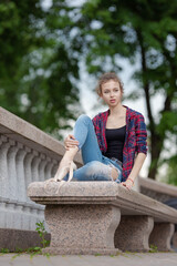 Girl ballerina in jeans, a plaid shirt and pointe shoes dancing in the city on the street © Tatiana