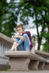Girl ballerina in jeans, a plaid shirt and pointe shoes dancing in the city on the street © Tatiana