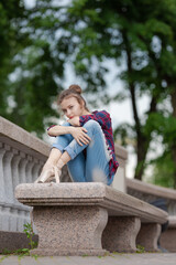 Girl ballerina in jeans, a plaid shirt and pointe shoes dancing in the city on the street © Tatiana