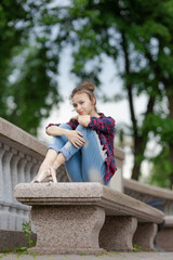 Girl ballerina in jeans, a plaid shirt and pointe shoes dancing in the city on the street © Tatiana