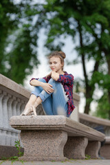 Girl ballerina in jeans, a plaid shirt and pointe shoes dancing in the city on the street © Tatiana