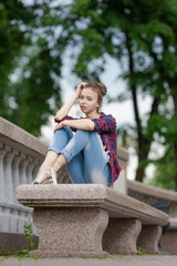 Girl ballerina in jeans, a plaid shirt and pointe shoes dancing in the city on the street © Tatiana