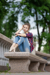 Girl ballerina in jeans, a plaid shirt and pointe shoes dancing in the city on the street © Tatiana
