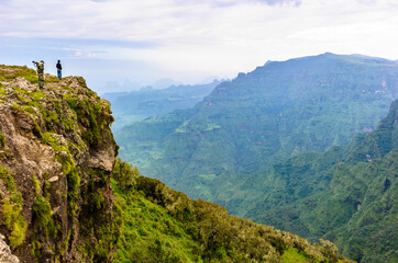 Fototapeta premium It's Man with a gun stay on the edge of the mountain and thinks