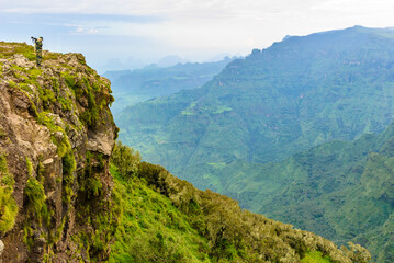 It's Man with a gun stay on the edge of the mountain and thinks